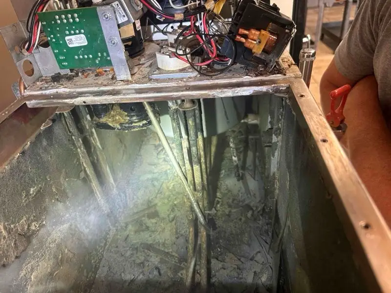 Mineral buildup and debris inside a commercial hot water tank