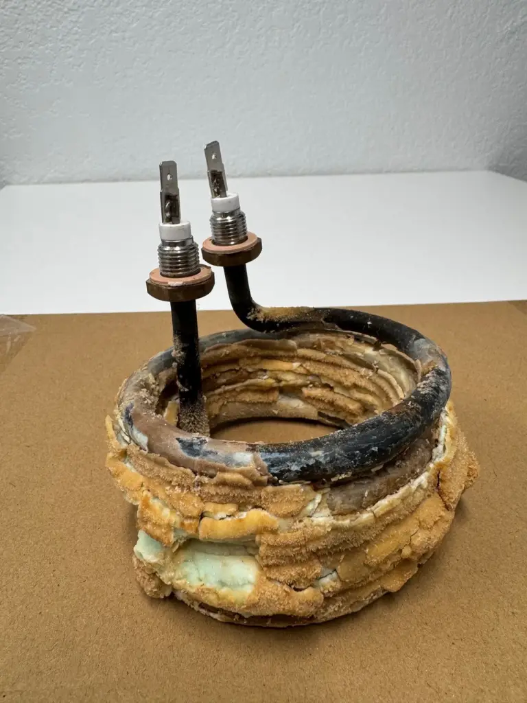 Heating element from a commercial coffee brewer completely encased in lime scale