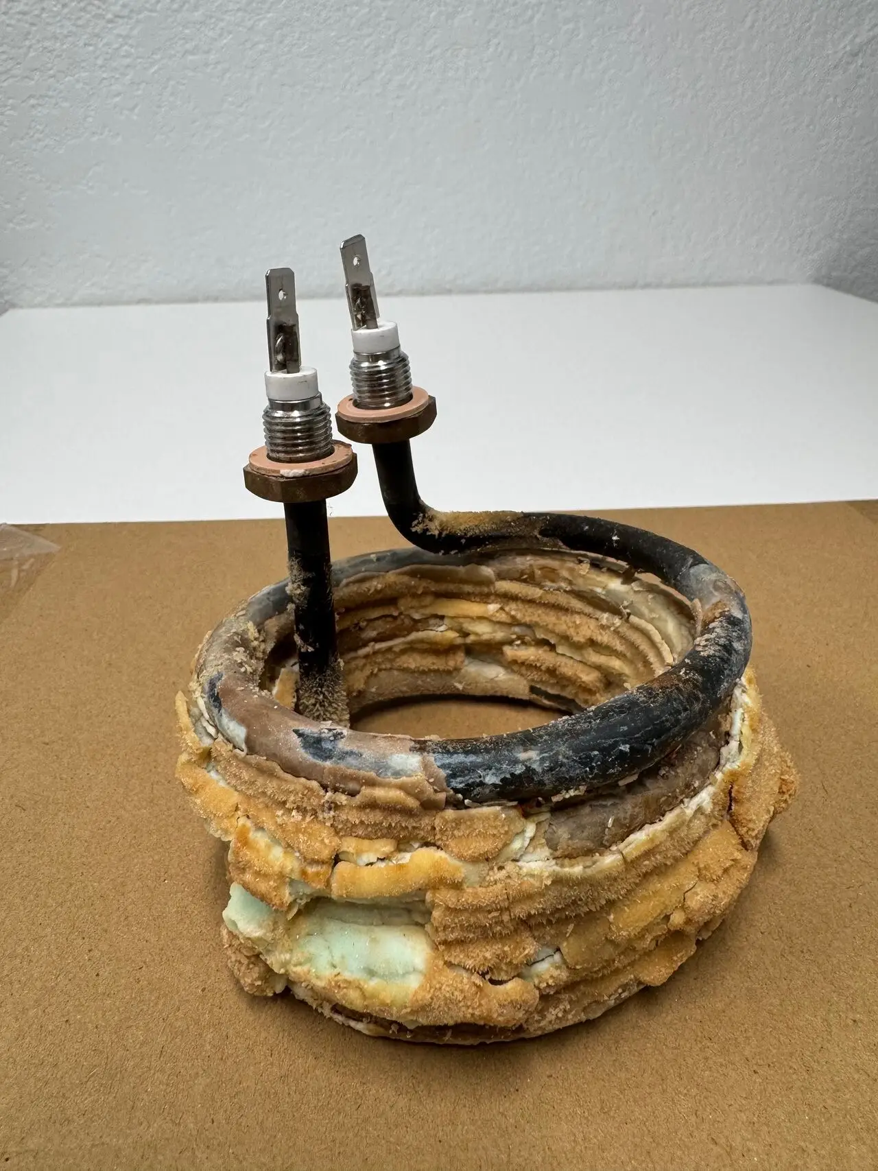 Heating element from a commercial coffee brewer completely encased in lime scale