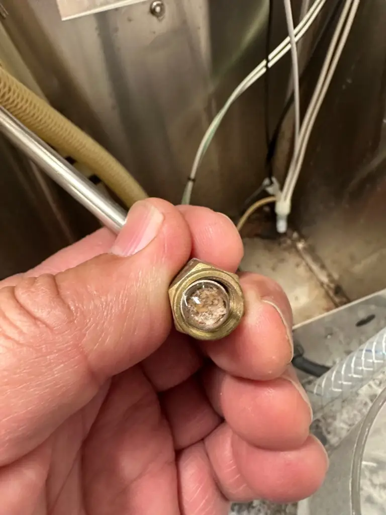 Brass tank fitting clogged with lime scale
