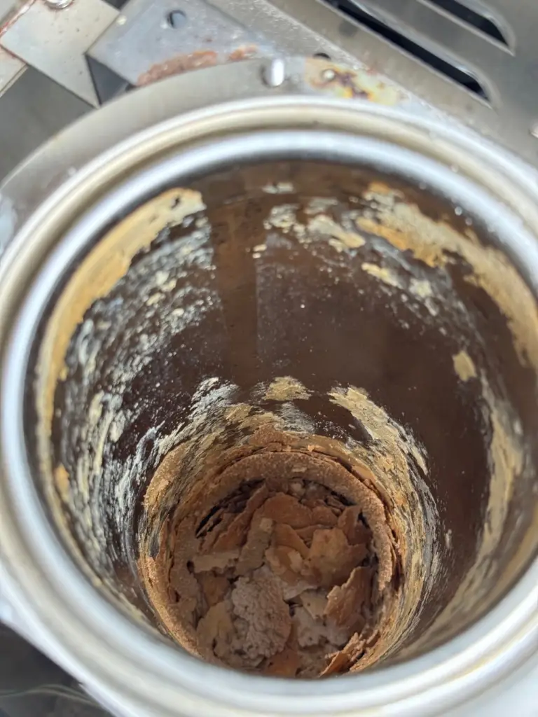 Thick layers of lime scale built up inside a commercial brewer tank