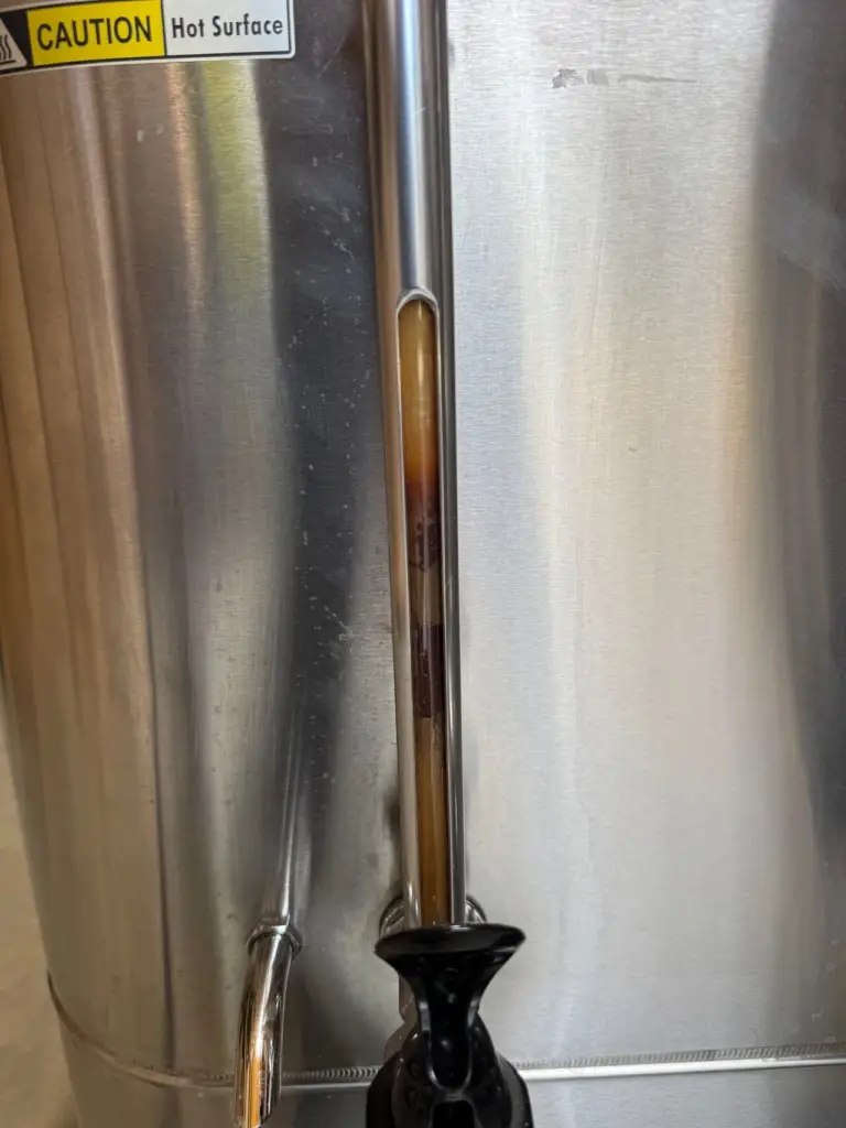 Coffee urn level gauge stained with old coffee residue